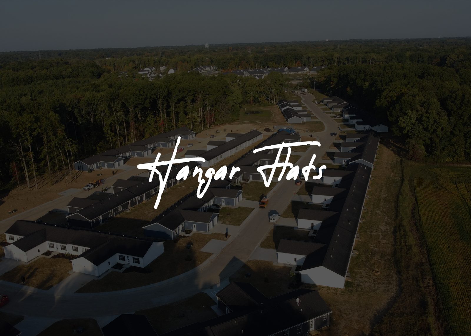 Aerial view of Hangar Flats with the community name over the image, by Alex Papa